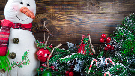 Christmas background with copy space, suitable for postcards and gift bags.Christmas toy snowman with christmas tree toy on wooden background with copy space, front viewの写真素材