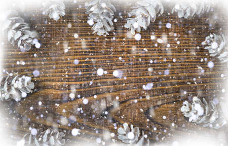 Beautiful white cones and snow on a brown wooden table, christmas winter background with copy spaceの写真素材