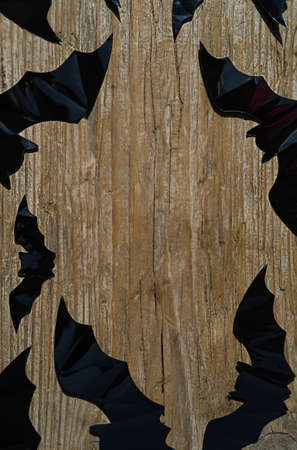 black bats on a wooden background with copy space in the centerの写真素材