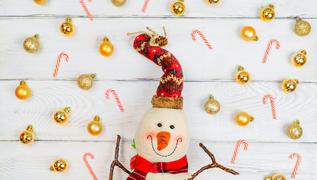 Christmas toy snowman on white wooden background with copy space, front view for postcards and gift bagsの写真素材