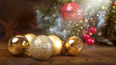Golden christmas balls on a wooden background with lights and copy spaceの写真素材