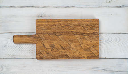Wooden textured cutting board on a white wooden kitchen tableの写真素材