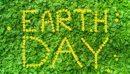 The inscription of flowers Earth Day on the grass top viewの写真素材
