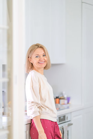 Young beautiful blonde girl at home in the kitchenの写真素材