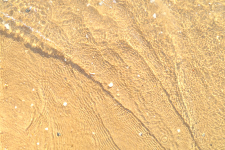 Sand with stones and sea water top view backgroundの写真素材