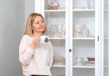 Young beautiful blonde girl at home in the kitchenの写真素材