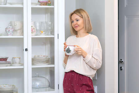 Young beautiful blonde girl at home in the kitchenの写真素材