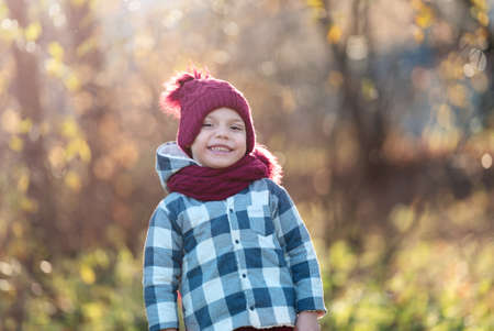 Portrait of a smiling little boy in a hat and scarf in autumn with copy spaceの写真素材