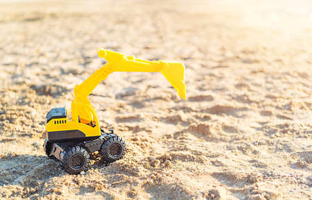 Toy excavator on the beach with copy spaceの写真素材