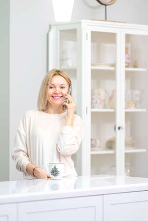 Young beautiful blonde girl at home in the kitchenの写真素材