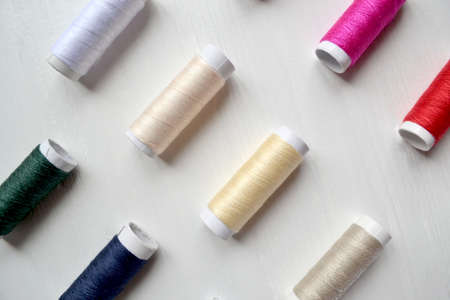 Coolorful thread coils on the white background with place for text.