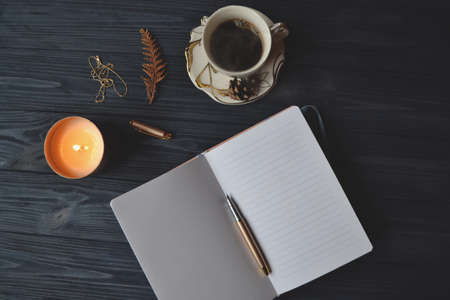 Vintage objects and a cup of coffee on the wooden table. Atmosphere of relax, dream, art or work.の写真素材