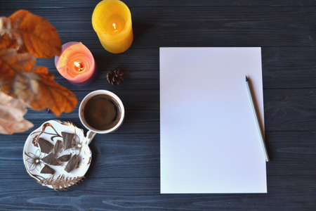 Cozy workplace. Place for art. Coffee, candles and paper on the desk.の写真素材