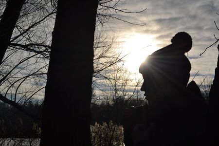 Sunset in winter park. Woman's face sihlouette.の写真素材