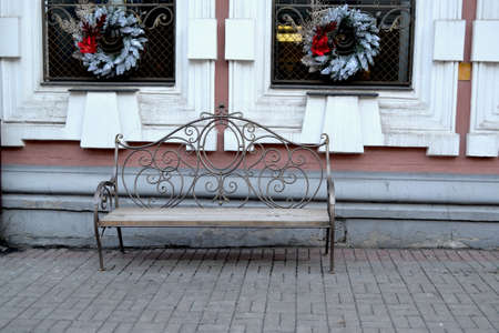 Vintage bench on the street. Chtistmas decoration on the house.の写真素材