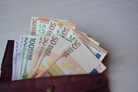 Euro money banknotes and wallet on the white wooden desk. Business money background.の写真素材