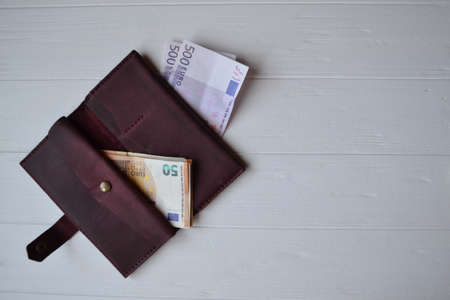Euro money banknotes and wallet on the white wooden desk. Business money background.の写真素材