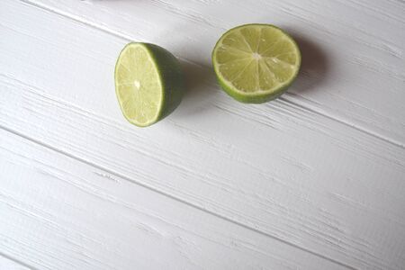 Lime on the white wooden background.
