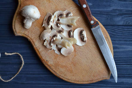 Mushrooms on the dark blue wooden desk. Cooking champignons.の写真素材