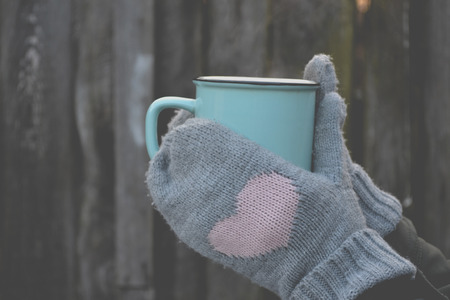 A mug of tea in cold weather. A cup of tea in a woman's hands.の写真素材