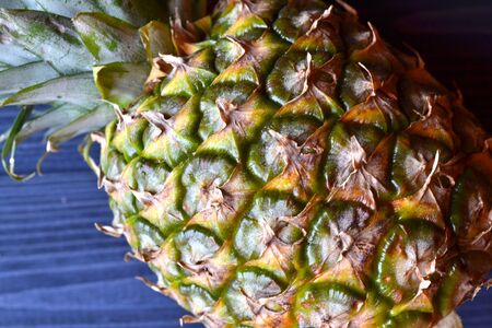 Pineapple on the dark blue wooden table. Summer background.の写真素材