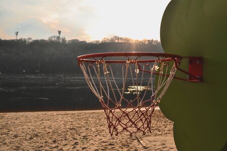 Basketball on the sunset beach. Basketball ring on the beach.