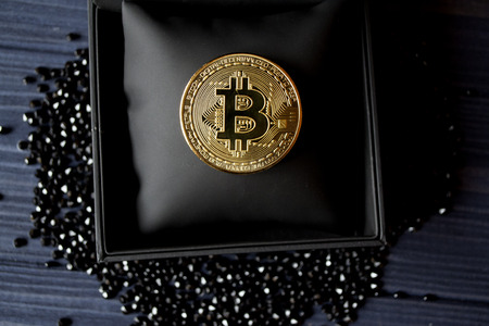 Golden bitcoin in a black box. Gold coin of cryptocurrency.の写真素材