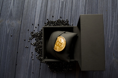 Golden bitcoin in a black box. Gold coin of cryptocurrency.の写真素材