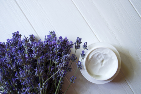 Lavender flowers and cream on a white wooden background. Beauty care.の写真素材