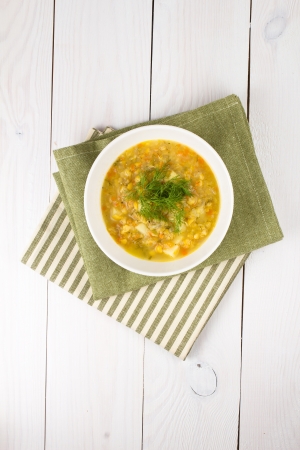 A bowl of thick, fresh, pea soup with herbs, vegetarian on wooden backgroundの写真素材