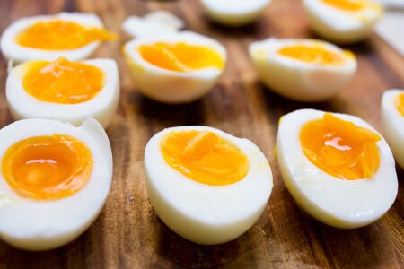 Hard boiled eggs, sliced in halves on wooden backgroundの写真素材