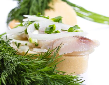 Sandwiches of white bread with herring, onions and herbs on white backgroundの写真素材