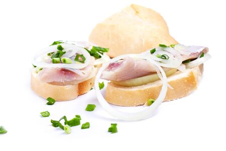 Sandwiches of white bread with herring, onions and herbs on white backgroundの写真素材