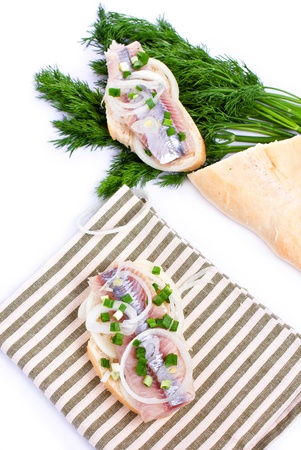 Sandwiches of white bread with herring, onions and herbs on white backgroundの写真素材