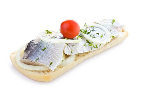 Sandwich with herring, onions, cherry tomato and herbs, isolatedの写真素材