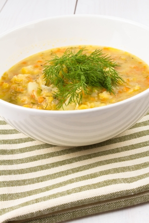 A bowl of thick, fresh, pea soup with herbs, vegetarian on wooden backgroundの写真素材