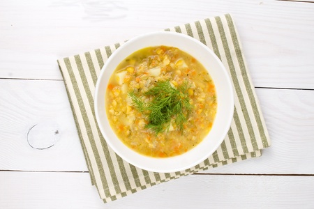 A bowl of thick, fresh, pea soup with herbs, vegetarian on wooden backgroundの写真素材