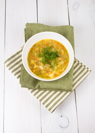 A bowl of thick, fresh, pea soup with herbs, vegetarian on wooden backgroundの写真素材