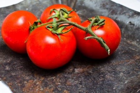 Bunch of fresh ripe tomatoes on vintage dark background closeupの写真素材