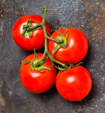 Bunch of fresh ripe tomatoes on vintage dark background closeupの写真素材