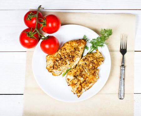 Grilled chicken breasts fillet with fresh vegetables on a white plate の写真素材