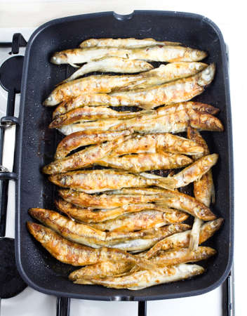 Fried small smelt tasty fish on a barbecue grill  hotplate