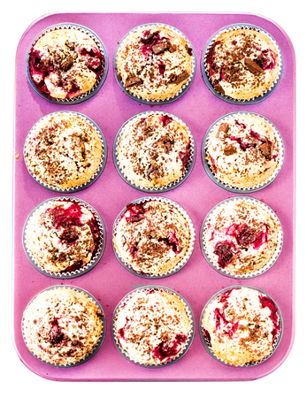 Muffins with Chocolade and Cherry in a pink colored baking tray isolated on white may use as food backgroundの写真素材