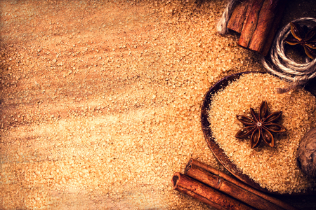 Food background with copy space. Brown sugar, anise star and cinnamon sticks on wooden background close up, still life.の写真素材