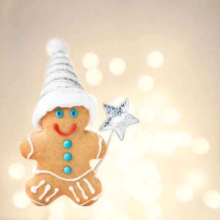 Christmas Gingerbread Man Cookie with Santa hat  on sparkling festive background with copyspace for text, closeup.の写真素材