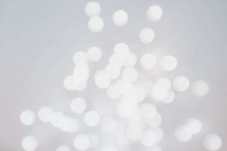 White and silver Festive Sparkle Background.  Abstract twinkled bright background with bokeh defocused blur lights. Festive Sparkle Background. の写真素材