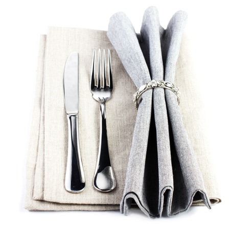 Elegant  Serving table setting place in silver and grey color isolated on white background. Linen textile napkin with cutlery - knife and fork,の写真素材