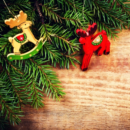 Christmas Fir Tree Branch on rustic  wooden background with festive ornaments and copy space for greeting text. Christmas Deer over wood.の写真素材
