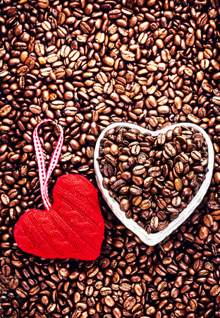 Roasted Coffee Beans with Red Heart over coffee beans background. Wedding, love, holiday,  Valentine Day Card. Love Coffee at Valentine's Day.の写真素材