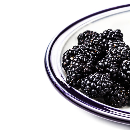 Fresh Blackberries in a bowl isolated on white background, close up. Summer berries, selective focus, macro.の写真素材